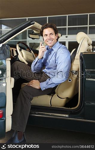 Man Sitting in a Convertible Talking on a Cell Phone