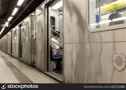 Man sitting in a train at a subway station, New York City, New York State, USA