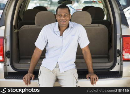 Man sitting in back of van smiling