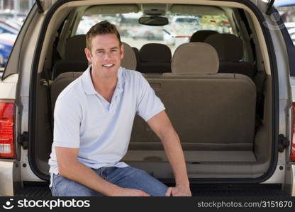 Man sitting in back of van smiling