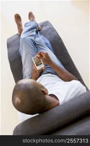 Man sitting in chair using personal digital assistant