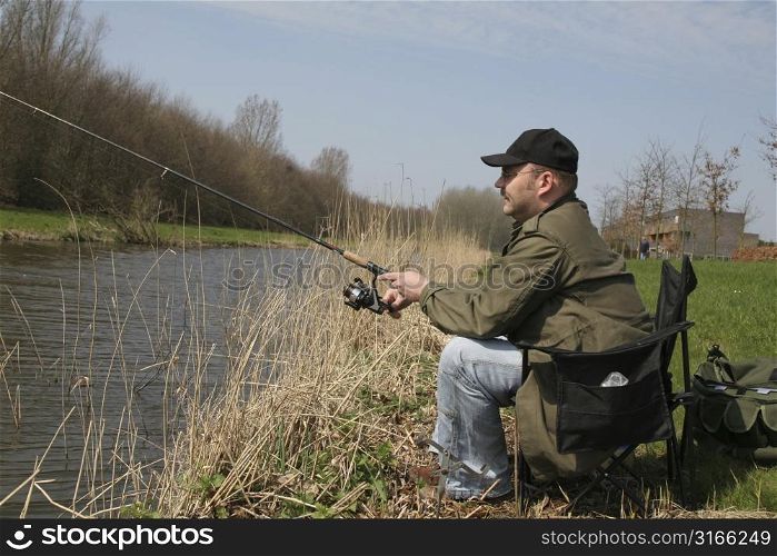 Man sitting in his fishing chair reeling in