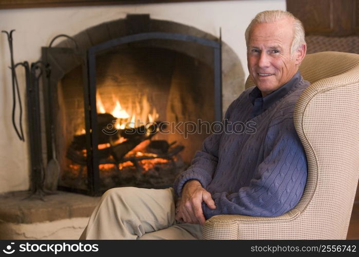 Man sitting in living room by fireplace smiling