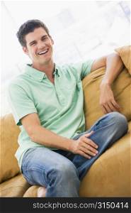 Man sitting in living room laughing