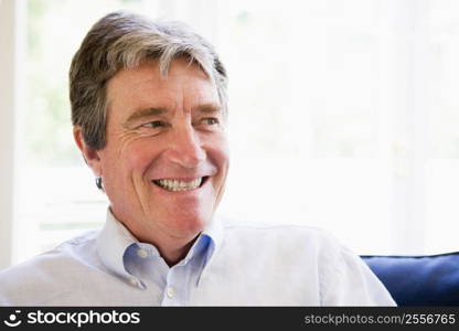 Man sitting in living room smiling