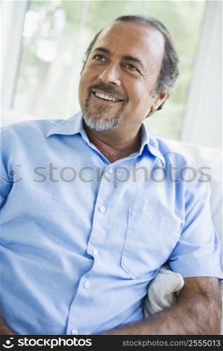 Man sitting in living room smiling (high key/selective focus)