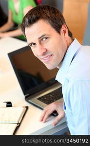 Man sitting in office in front of laptop computer