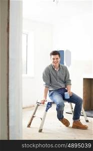 Man Sitting In Property Being Renovated