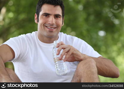 man sitting in the park and drinking water