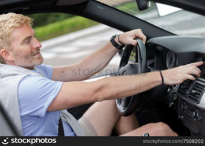 man sitting inside vehicle in car dealership