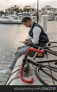 man sitting lake with his bike 2