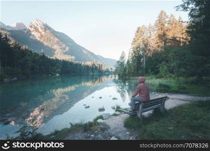 Man sitting near the mountain lake