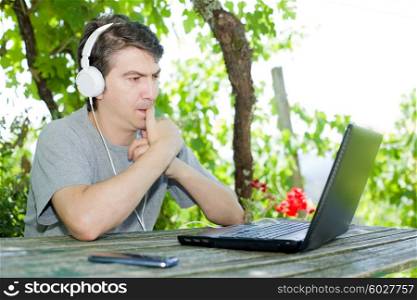 man sitting on a table working with a laptop