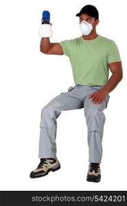 Man sitting on an invisible stool and holding a spray gun