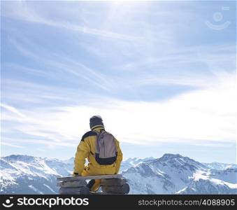 Man sitting on bench on mountain top