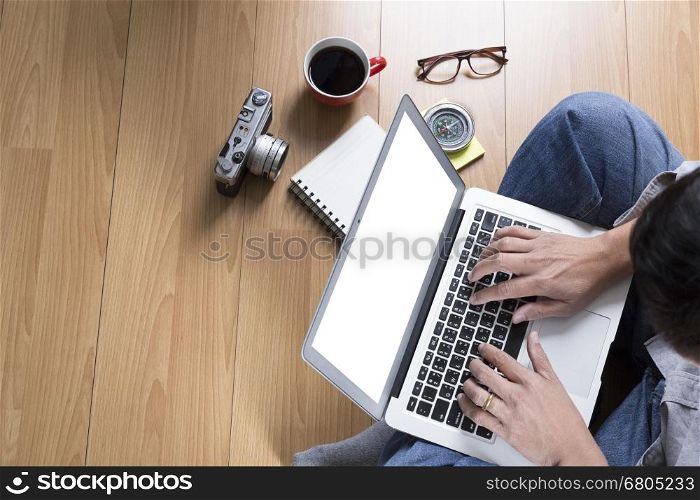 man sitting on floor with laptop computer, coffee cup and eyeglasses - top view