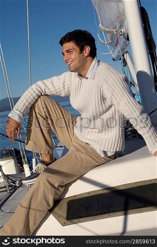 Man Sitting on Sailboat Deck
