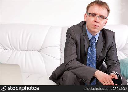 Man sitting on sofa and speaking on the telephone