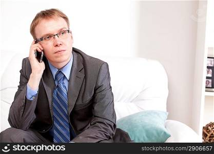 Man sitting on sofa and speaking on the telephone
