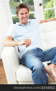 Man Sitting On Sofa Relaxing At Home