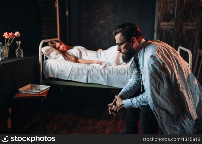 Man sitting on the chair against young ill woman in the hospital. Illness of female patient in clinic, health recovery and treatment. Man sitting on the chair against young ill woman