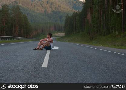 Man sitting on the road. Man sitting on the beauty road in mountain