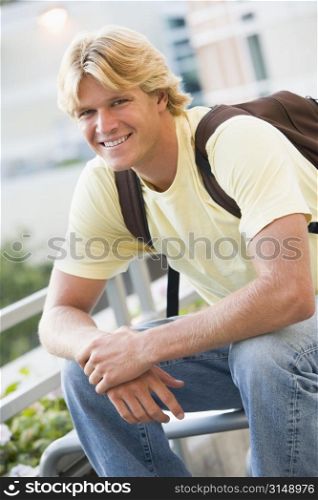 Man sitting outdoors on bench smiling (selective focus)