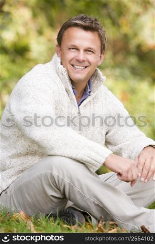 Man sitting outdoors smiling (selective focus)