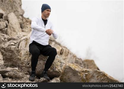 man sitting rocks nature