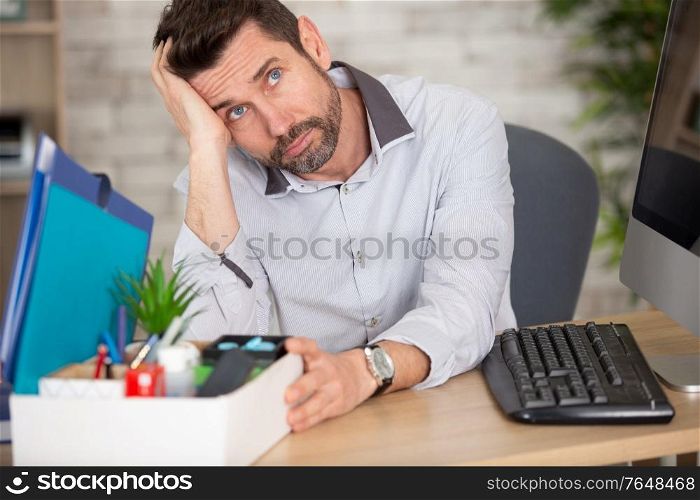 man sitting sadly near the box with his stuff