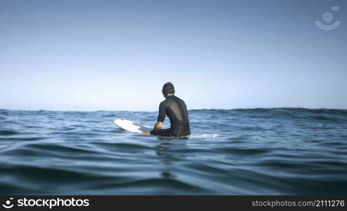 man sitting water from back shot