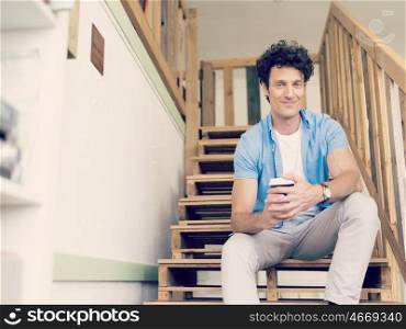 Man sitting with a mug on the stairs