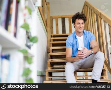 Man sitting with a mug on the stairs