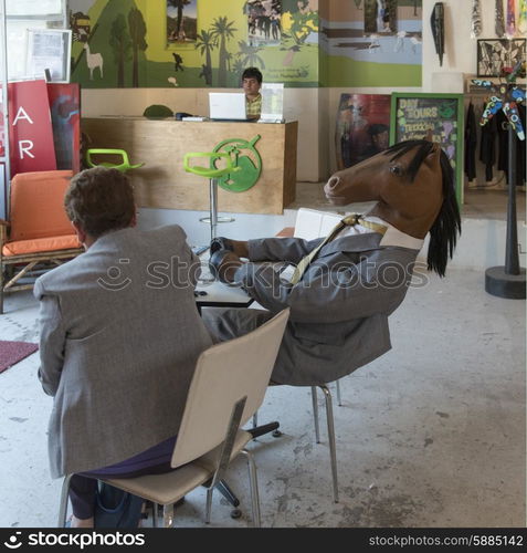 Man sitting with a person wearing a horse costume, Santiago, Santiago Metropolitan Region, Chile