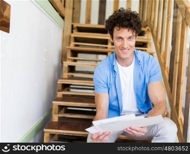 Man sitting with papers on the stairs