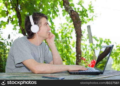 man sitting working and daydreaming with a laptop