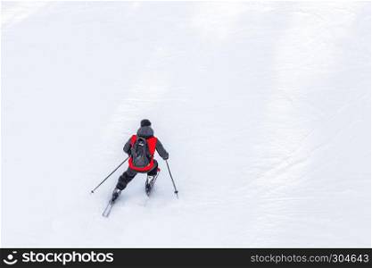 Man skier with red coat and black backpack skiing on fresh white snow on ski slope on Sunny winter day with Copy space in uludag mountain Bursa,Turkey.. Man skier with red coat and black backpack skiing