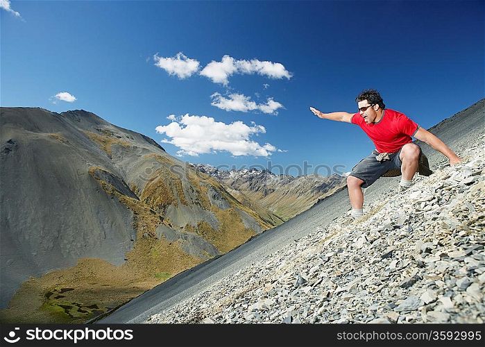 Man sliding down screen field in mountains