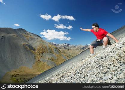 Man sliding down screen field in mountains
