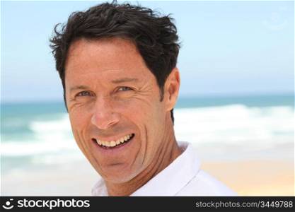 Man smiling at the seaside.