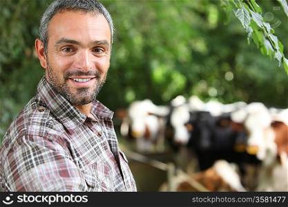 Man smiling in front of cows