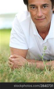 Man smiling laid on the grass