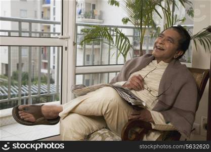 Man smiling while relaxing in his house