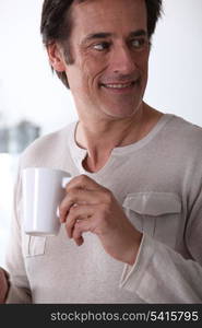 Man smiling with a cup of tea.