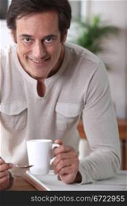 Man smiling with a cup of tea.