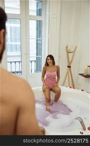man smiling woman spa tub with water foam