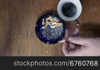 Man smoking a cigarette, one by one and drinking several cups of coffee