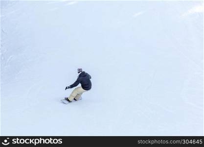 Man snowboarder snowboarding on fresh white snow on ski slope on Sunny winter day in uludag mountain Bursa,Turkey.Copy space.. Man snowboarder snowboarding on fresh white snow