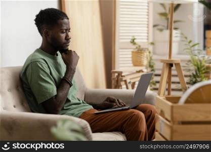 man sofa making plan redecorate home using laptop