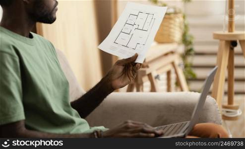 man sofa making plan redecorate house using laptop